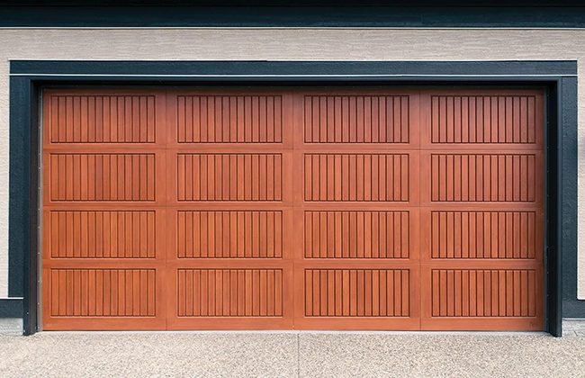 Modern wooden garage door with vertical grooves, set in a residential home exterior.