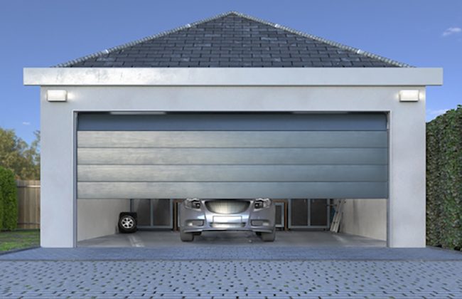 Modern garage with an open door revealing a car inside, surrounded by clean driveway and greenery.